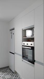 uma cozinha com armários brancos e um forno em SuecaRoom em Sueca