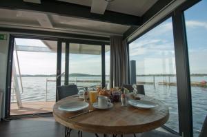 a wooden table with food on it in a room with windows at Hausboot Moin Madita in exklusiver Lage in Schleswig