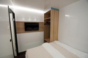 a bedroom with a bed and a flat screen tv at Hausboot Moin Madita in exklusiver Lage in Schleswig