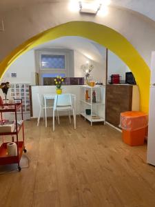 uma sala de estar com uma mesa e um arco amarelo em casa vacanze Luca intero alloggio em Catânia