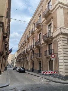 um edifício com carros estacionados ao lado de uma rua em casa vacanze Luca intero alloggio em Catânia
