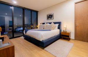 1 dormitorio con 1 cama grande y ventanas de cristal en Capitalia - Apartments - Downtown del Valle en Ciudad de México