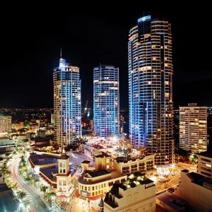 
a city at night with a large building at Mantra Towers of Chevron in Gold Coast
