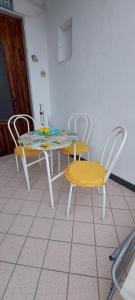 mesa de comedor y sillas en una sala con mesa y sillón en Casa Rosa sopra la Costiera, en San Lazzaro Agerola