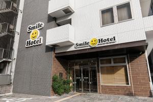 a smiley hotel sign on the side of a building at Smile Hotel Hakataekimae in Fukuoka