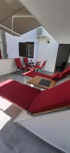 a room with red chairs and tables on a boat at Old Town Baska in Baška