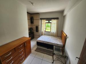 a small room with a bed and a window at Residencial Silveira in Itajaí