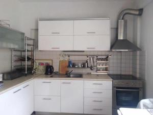 a kitchen with white cabinets and a sink at Spacious 3 bed house with sea view in Possidi +12 photos