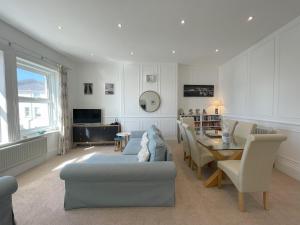 uma sala de estar com um sofá azul e uma mesa em Sandy Toes - awesome beach view and access em Ventnor