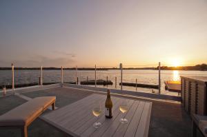 - une table en bois avec des verres à vin et une bouteille de vin dans l'établissement Hausboot Moin Madita in exklusiver Lage, à Schleswig
