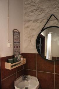 La salle de bains est pourvue d'un miroir et d'un lavabo. dans l'établissement Lugar São Salvador de Monsanto, à Monsanto