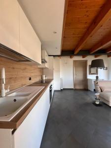Grazioso appartamento في أَويستا: مطبخ مع حوض واريكة في الغرفة