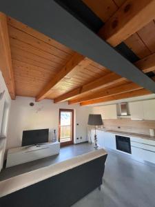 a large living room with wooden ceilings and a window at Grazioso appartamento in Aosta