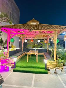 a gazebo with a picnic table in a garden at The Grey House! in Noida