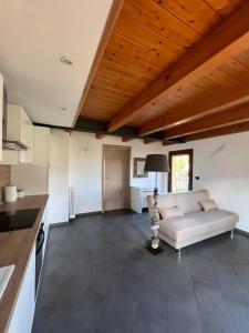 sala de estar con sofá blanco y techo de madera en Grazioso appartamento en Aosta