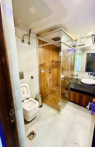 a bathroom with a toilet and a shower and a sink at The Grey House! in Noida