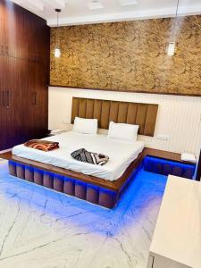 a bedroom with a large bed with a blue floor at The Grey House! in Noida