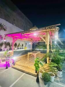 a wooden gazebo with pink lights on it at The Grey House! in Noida