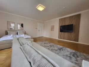 a bedroom with two beds and a flat screen tv at SiOUX stilvoll eingerichtete Apartments im Stadtkern I NETFLIX I NESPRESSO I in Kaufbeuren