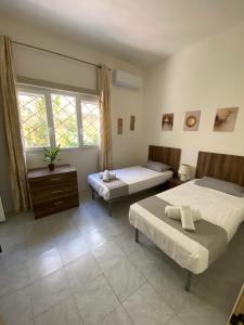Spacious room with 2 single beds shared bathroom, st Julians في Tal-Għoqod: غرفة نوم بسريرين ونافذة