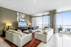 Sala de estar con 2 sofás blancos y TV en Mantra Towers of Chevron, en Gold Coast
