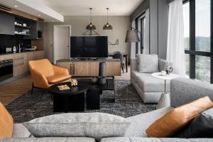 a living room with a couch and a tv at Johannesburg Marriott Hotel Melrose Arch in Johannesburg