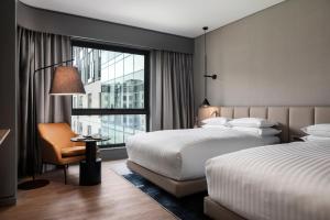 a hotel room with two beds and a window at Johannesburg Marriott Hotel Melrose Arch in Johannesburg