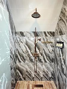 y baño con ducha y azulejos de mármol. en Boscaje Solarpunk Habitat, en La Gran Via
