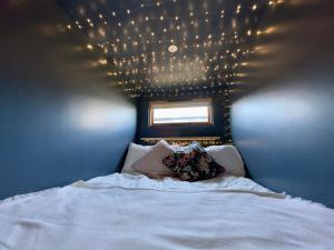a bedroom with a bed with lights on the ceiling at The Snug: Dorset hideaway in Blandford Forum