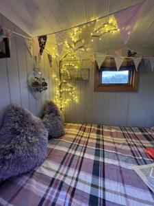 A bed or beds in a room at Oakley View Shepherds Hut with hot tub