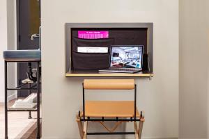 a desk with a chair and a laptop on a shelf at MOXY NYC Times Square in New York