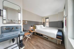 a hotel room with a bed and a sink at MOXY NYC Times Square in New York