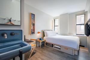a bedroom with a bed and a bath tub at MOXY NYC Times Square in New York