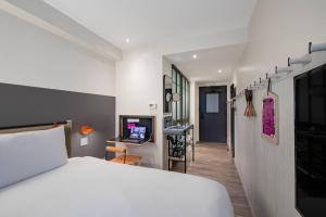 a bedroom with a bed and a hallway with a desk at MOXY NYC Times Square in New York