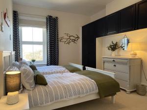 a bedroom with a bed and a dresser and a window at Sandy Toes - awesome beach view and access in Ventnor