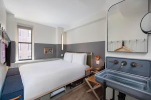 a bedroom with a bed and a sink at MOXY NYC Times Square in New York