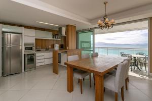 uma cozinha com uma mesa e vista para o oceano em Varanda com Churrasqueira e Vista MAR #CHA06 em Florianópolis