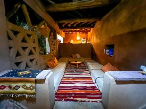 a living room with a couch and a rug at Dar Talmoudi in Tagounite
