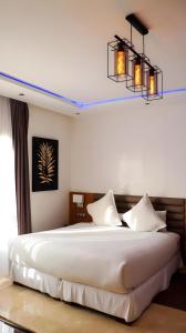 a bedroom with a large white bed with two lights at Appartement marina agadir in Agadir