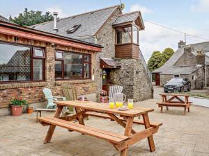 ein hölzerner Picknicktisch auf einer Terrasse vor einem Haus in der Unterkunft Driftwood Barn in Tenby + 5 Fotos