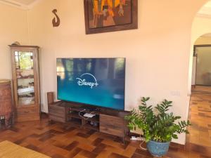 Villa MONOIHERE في Mahina: غرفة معيشة مع تلفزيون بشاشة مسطحة على جدار