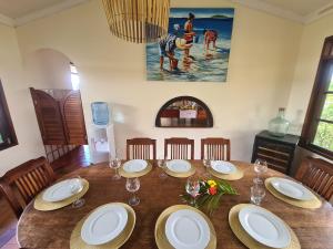 uma sala de jantar com uma mesa de madeira com placas e cadeiras em Villa MONOIHERE em Mahina