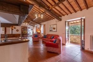 a living room with red chairs and a couch at Villa Palazzo Bello con piscina e AC - Cetona in Cetona
