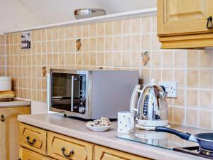 eine Küche mit einer Arbeitsplatte mit Mikrowelle in der Unterkunft Driftwood Barn in Tenby