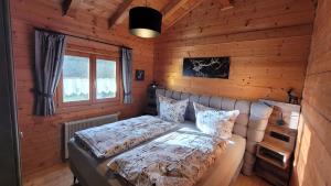 - une chambre avec un lit dans une cabane en rondins dans l'établissement Blockhäuser Stamsried, à Stamsried