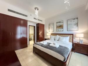a bedroom with a large bed with two towels on it at JBR Beach, The Walk, 1-BDR with pool view in Dubai
