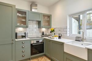 a kitchen with green cabinets and a sink at Modern house in Carbis Bay in Carbis Bay