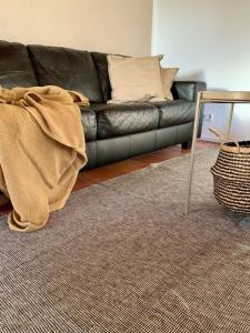 a living room with a black couch and a rug at Haus Elstar in Bodman-Ludwigshafen