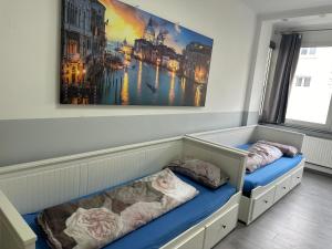 Cette chambre comprend deux lits et un tableau mural. dans l'établissement Modernes Apartment 4 mit 6 einzelnen Betten, à Dortmund