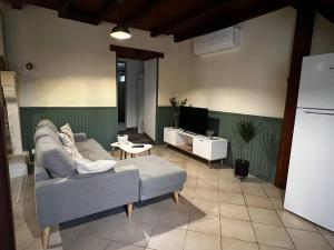 a living room with a couch and a tv at Gîtes du Fanal in Ébéon